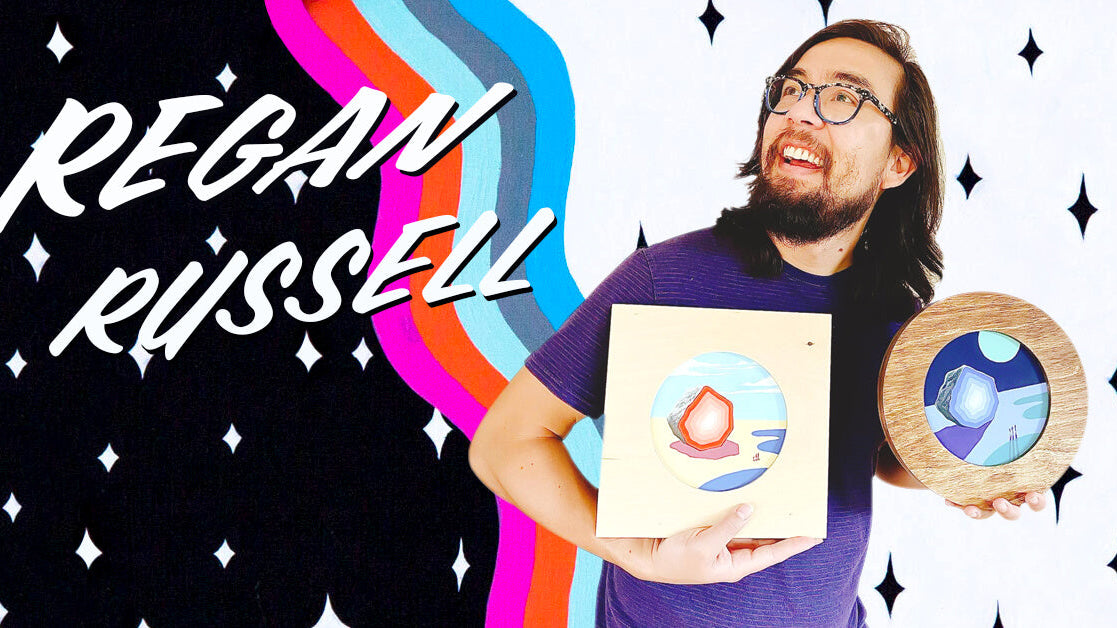 “I like to make artwork about pop culture and traversing the spaces between nostalgia and the unknown.” - Regan Russell holding his Portal pieces.