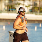 Man running by a waterfront with sunglasses wearing The Longhairs Bird of Prey Headwrap